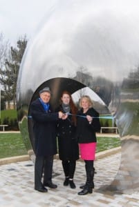 Three people in front of artwork